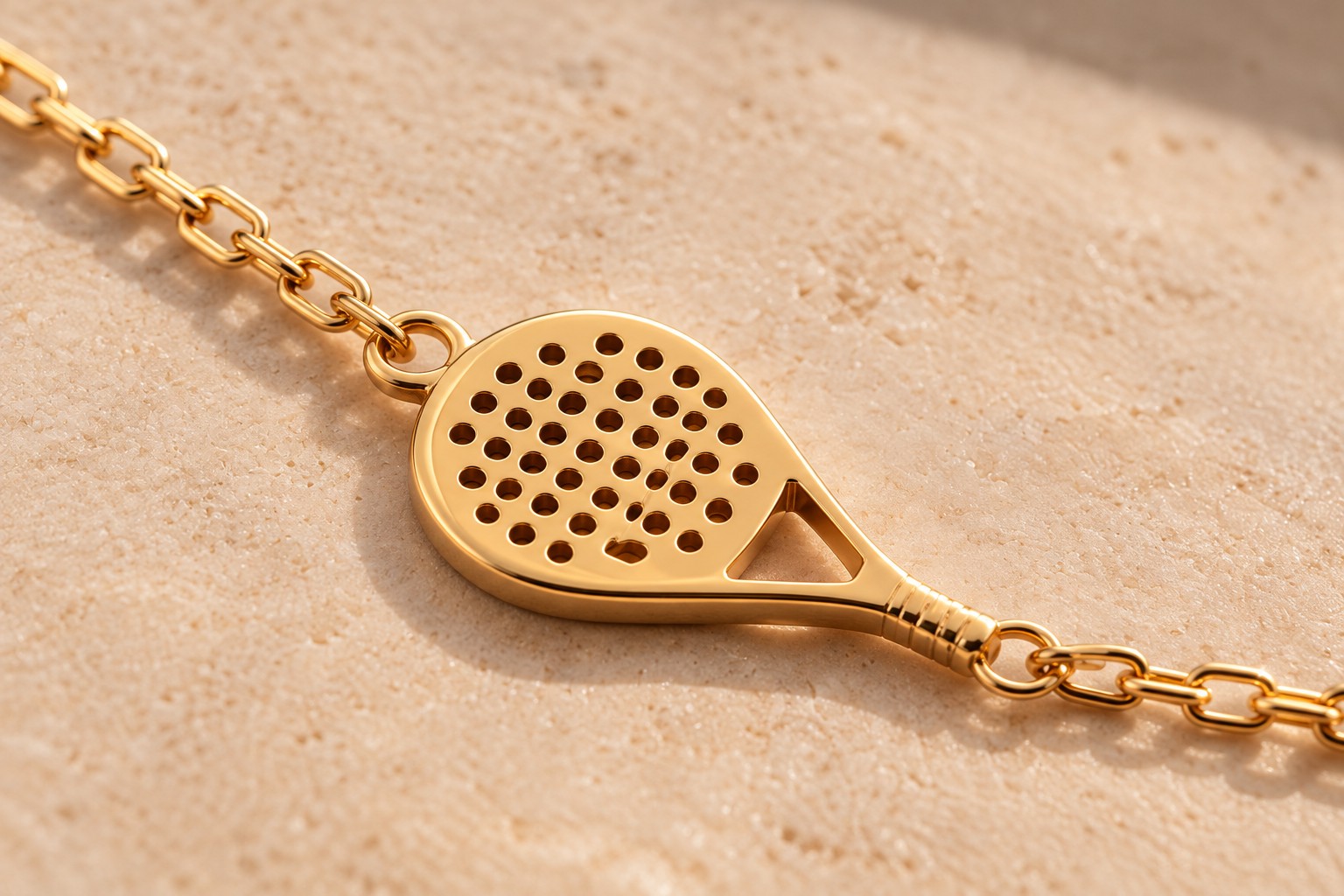 Raquette dorée ajourée du collier, sur pierre claire